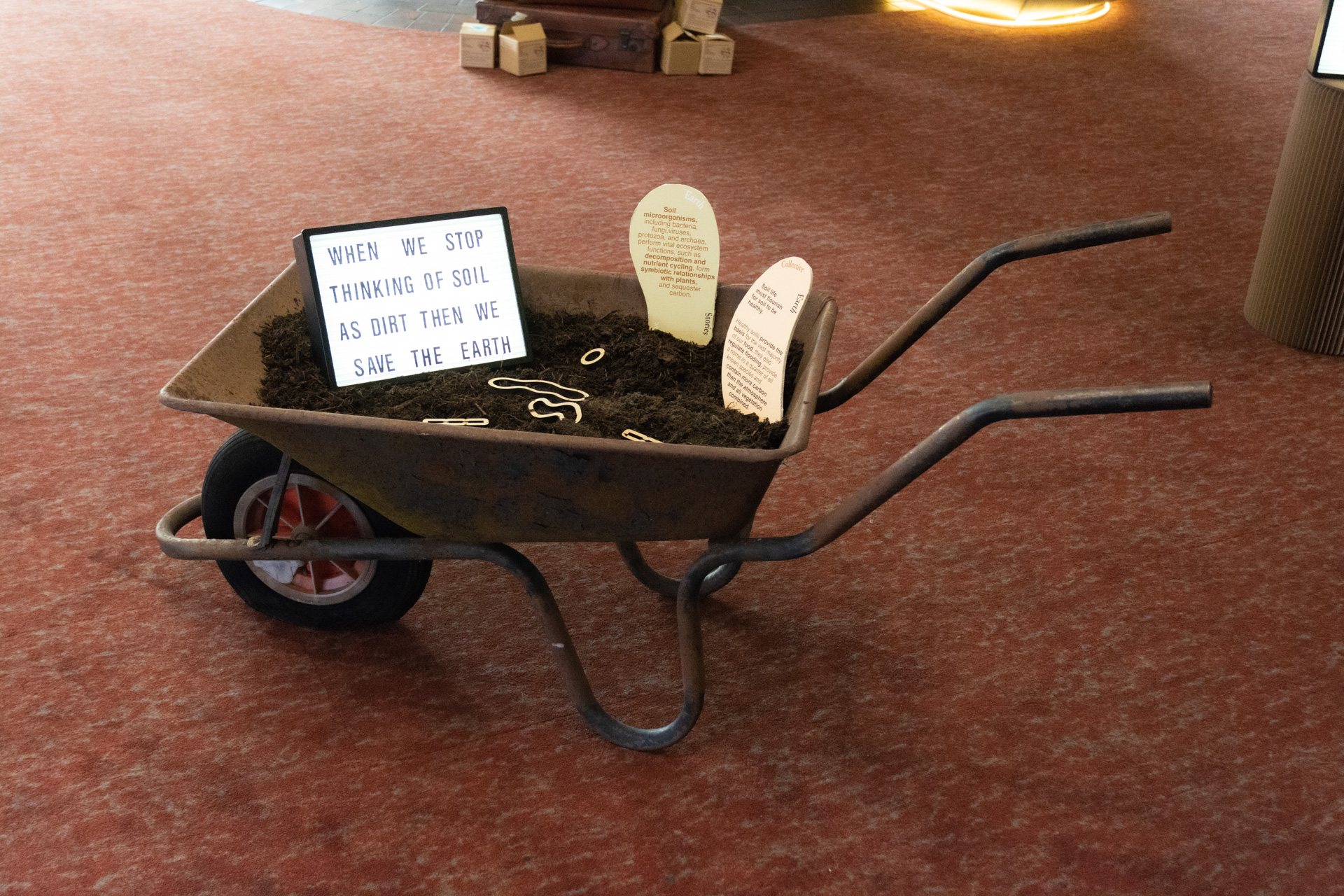 Wheelbarrow of soil with a light box and story cards